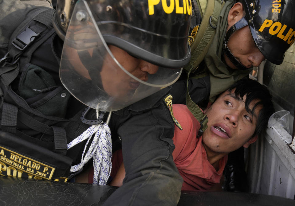 FILE - An anti-government protesters who traveled to the capital from across the country to march against Peruvian President Dina Boluarte, is detained and thrown on the back of police vehicle during clashes in Lima, Peru, Jan. 19, 2023. Protesters are seeking immediate elections, Boluarte's resignation, the release of ousted President Pedro Castillo and justice for up to 48 protesters killed in clashes with police. (AP Photo/Martin Mejia, File)