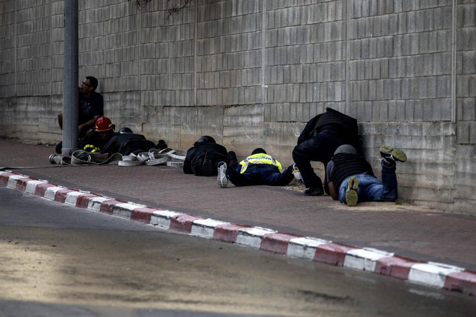 People take cover during an air-raid warning siren in Sderot, southern Israel , Israel, Tuesday, Nov. 12m 2019. Israel has killed a senior Islamic Jihad commander in Gaza in a rare targeted killing that threatened to unleash a fierce round of cross-border violence with Palestinian militants. (AP Photo/Tsafrir Abayov)