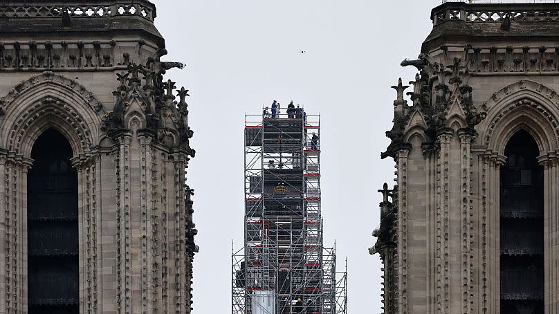 Macron (C) visits the reconstruction work and the cross atop the newly rebuilt spire, at Notre-Dame de Paris Cathedral.