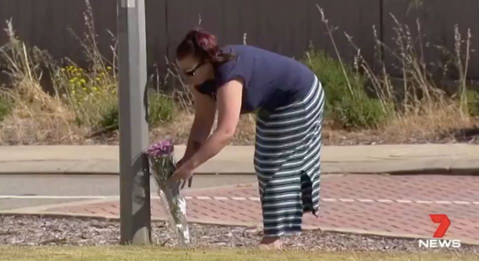 A neighbour lays flowers at the house where little Isabella died. Source: 7 News