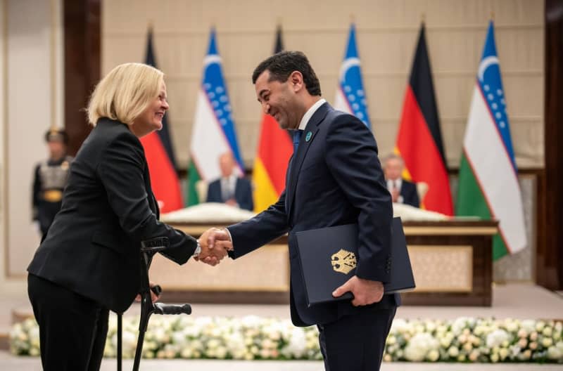 Nancy Faeser (L), German Interior Minister, shakes hands with her Uzbek counterpart Bakhtier Saidov after handing over a signed migration agreement. Michael Kappeler/dpa