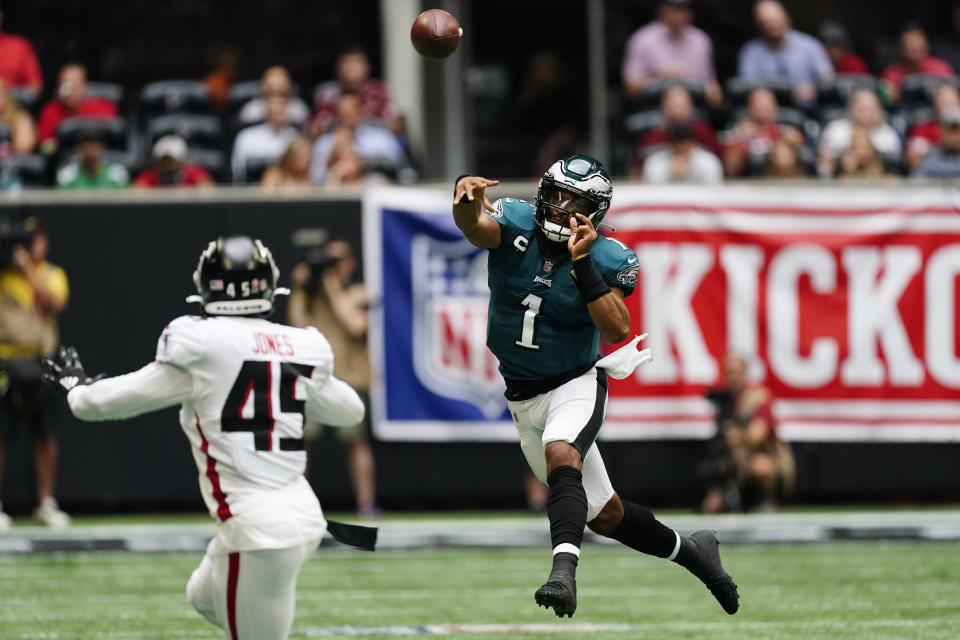 El quarterback de los Eagles de Filadelfia Jalen Hurts lanza el balón ante la mirada del linebacker de los Falcons de Atlanta, Deion Jones, en la primera mitad del juego del domingo 12 de septiembre de 2021, en Atlanta. (AP Foto/John Bazemore)