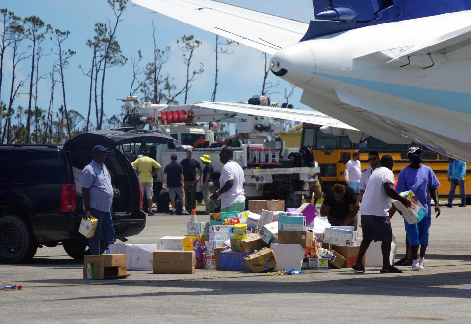 People unload humanitarian aid Sept. 7 at the Treasure Cay Airport in the Bahamas after the passage of Hurricane Dorian.