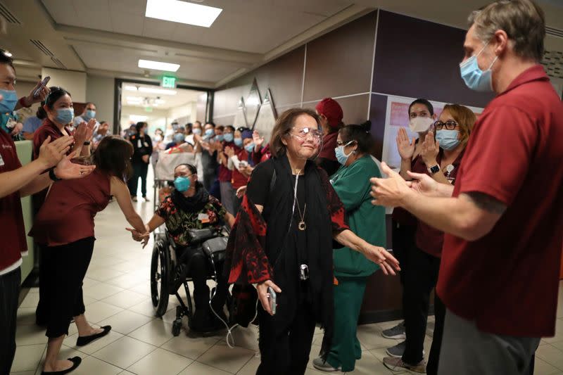 Intensive Care Unit Nurse Merlin Pambuan, is cheered by hospital staff as she walks out of the hospital in Long Beach