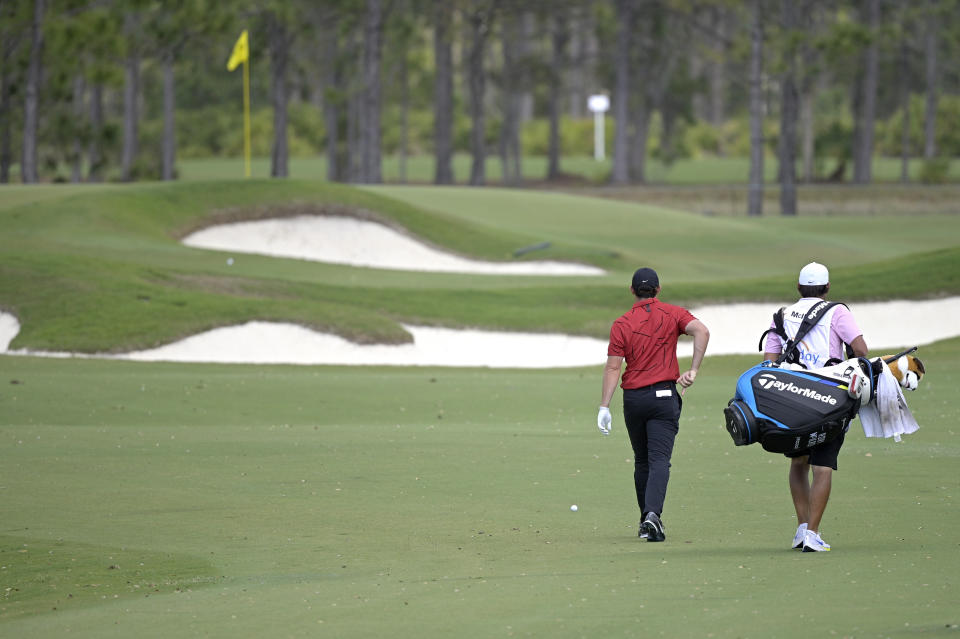 Rory McIlroy, of Northern Ireland, walks to his ball on the seventh fairway while wearing colors honoring Tiger Woods during the final round of the Workday Championship golf tournament Sunday, Feb. 28, 2021, in Bradenton, Fla. (AP Photo/Phelan M. Ebenhack)