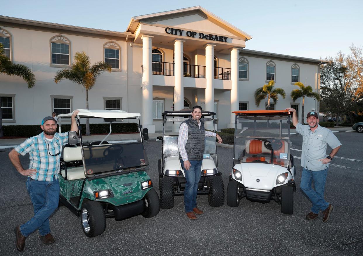 From left, Eric Hill, Kyle Tetreault and Donnie Taylor are pictured with their golf carts in front of DeBary's City Hall on March 2, 2022. The city allows permitted drivers to operate their golf carts on certain city roads, sidewalks and trails.