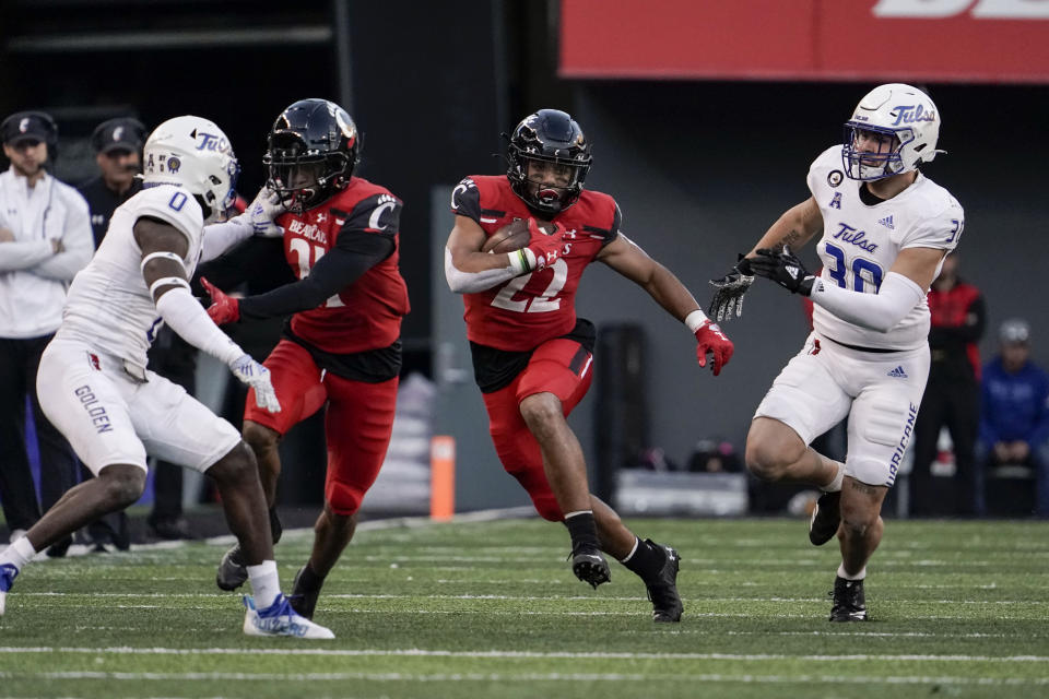 FILE - Cincinnati running back Ryan Montgomery (22) runs with the ball during the second half of an NCAA college football game against Tulsa Saturday, Nov. 6, 2021, in Cincinnati. Another competition playing out in camp is to replace 1,300-yard running back Jerome Ford. The returning candidates are senior Ryan Montgomery, who's been a top-notch punt returner for the Bearcats for three years, and senior Charles McClelland, who has had some bad luck with injuries. (AP Photo/Jeff Dean, File)