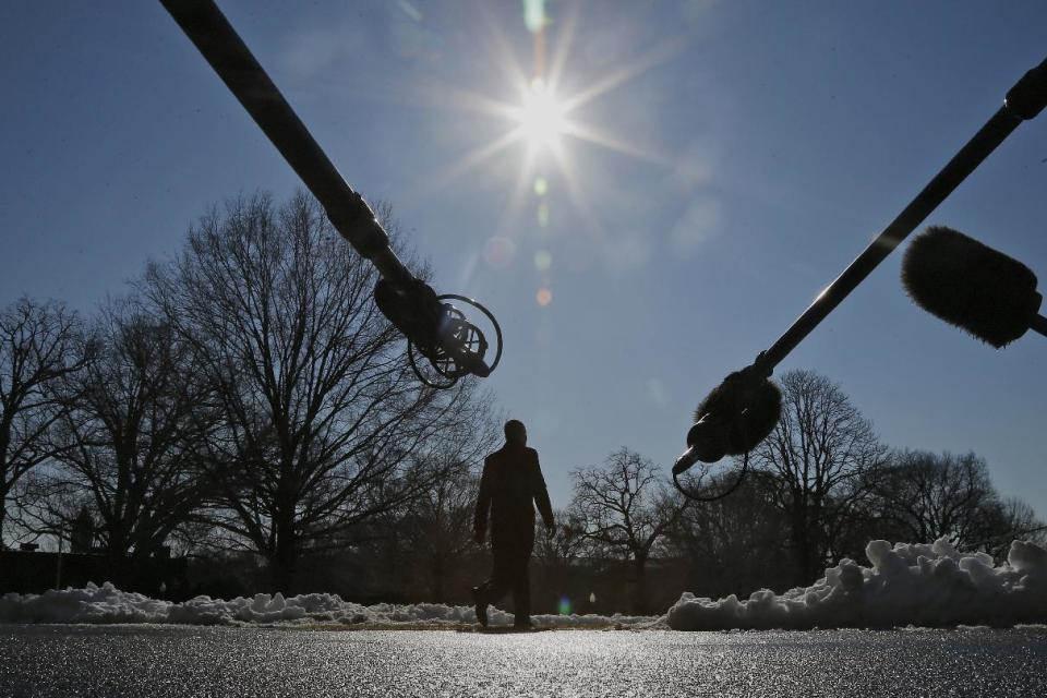 Microphones are extended towards President Barack Obama as he walks on the South Lawn of the White House in Washington, Friday, Feb. 14, 2014, before boarding the Marine One helicopter to travel to the Democratic House members retreat in Cambridge, Md. (AP Photo/Charles Dharapak)