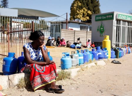 A woman waits to buy gas at a service station in Harare