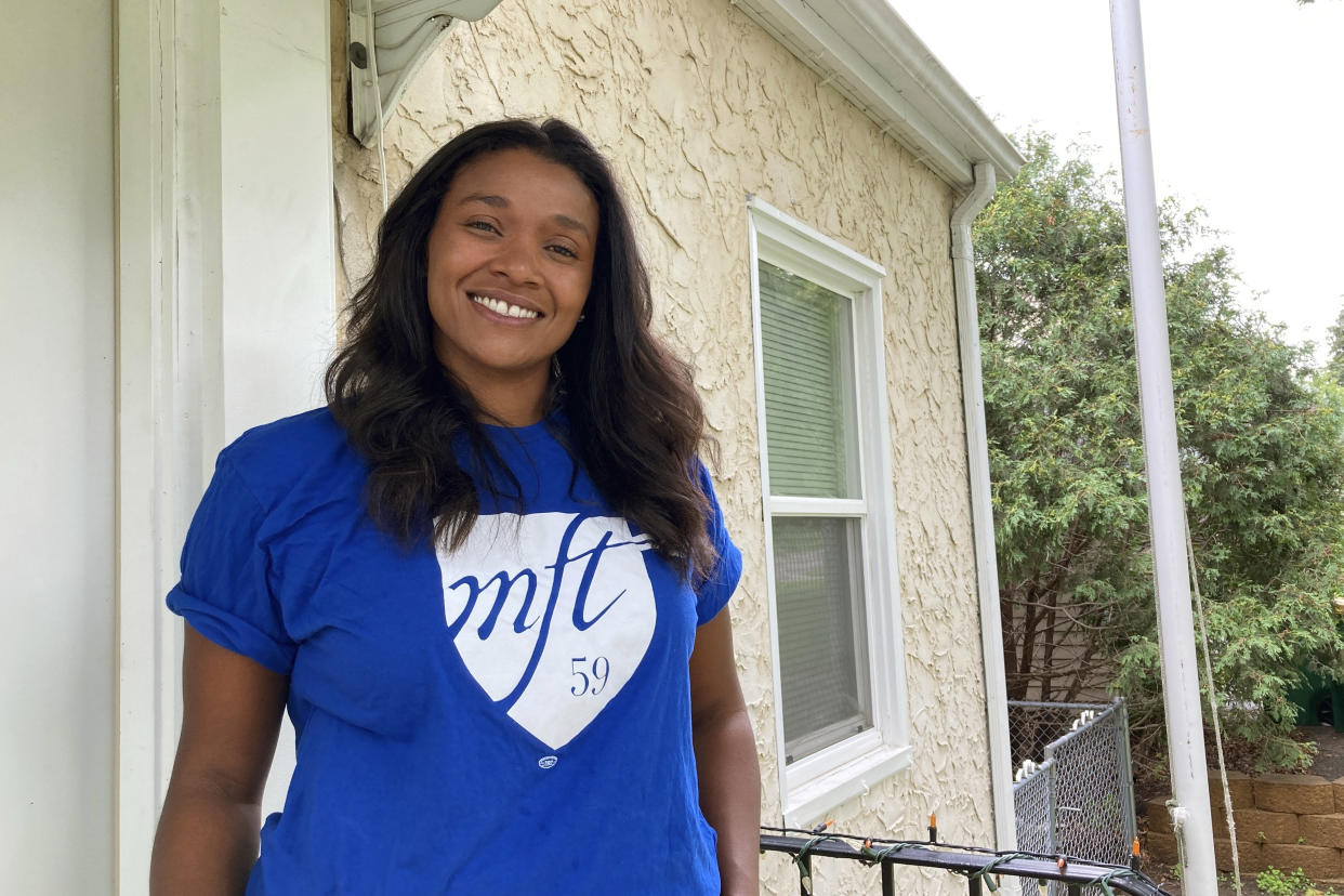 Lindsey West, a fifth-grade teacher at Clara Barton Community School in Minneapolis who identifies as Black and Indigenous, poses at her home in suburban Minneapolis on Friday, Aug. 19, 2022. A dispute has arisen over language in the new Minneapolis teachers contract that’s meant to protect teachers of color from layoffs. West said the seniority language is one piece of a bigger mission of improving education. (AP Photo/Steve Karnowski)