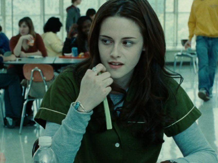 Bella holding a piece of celery against her cheek in the cafeteria in twilight