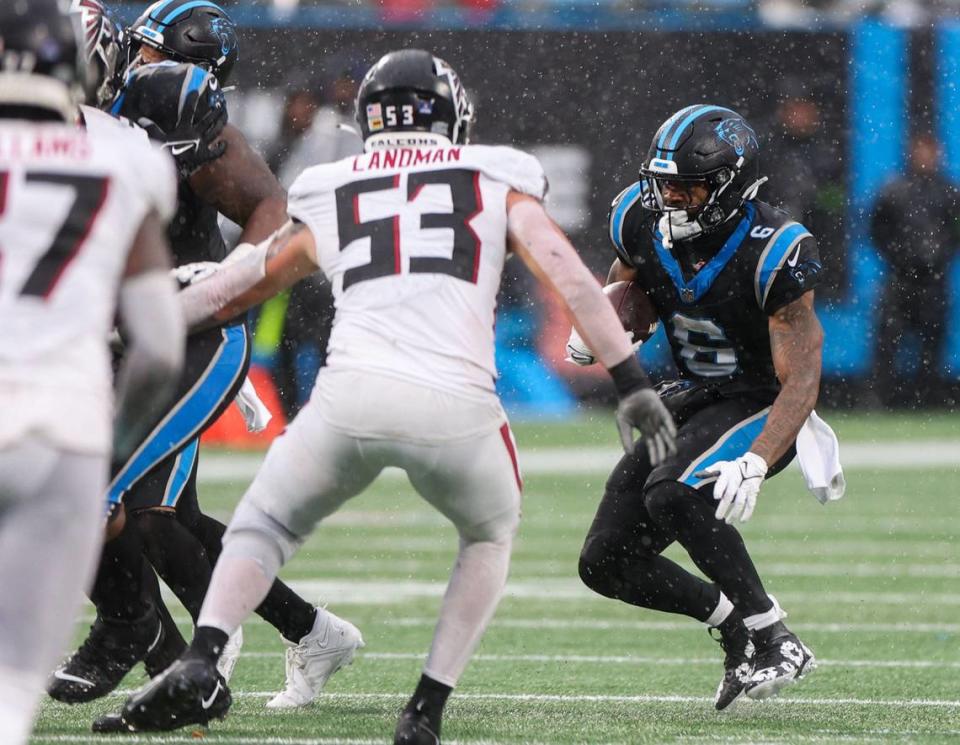 Panthers running back Miles Sanders, far right, looks for a break in the line during the game against the Falcons at Bank of America Stadium on Sunday, December 16, 2023.