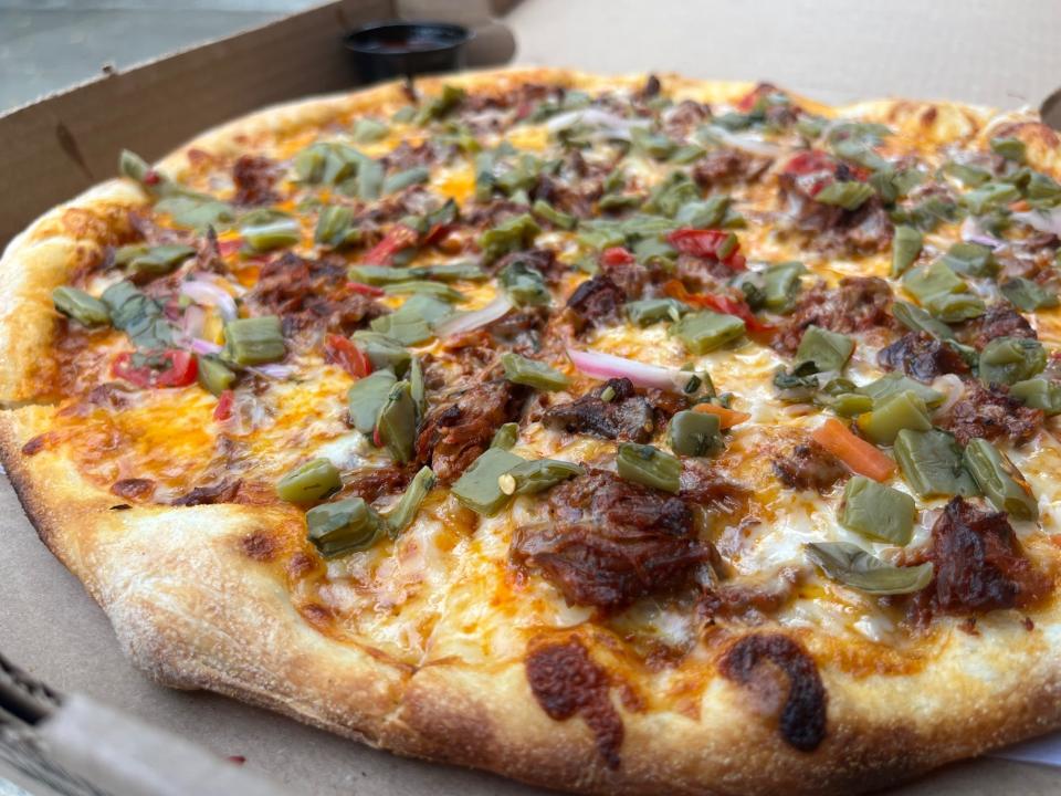 The borrego en adobo pizza is a specialty at South Philadelphia's Tonalli pizzeria and taqueria, which opened in summer 2023. The pizza dough is proofed overnight, and the braised and seasoned lamb mixiote served as pizza topping takes two days to prepare.