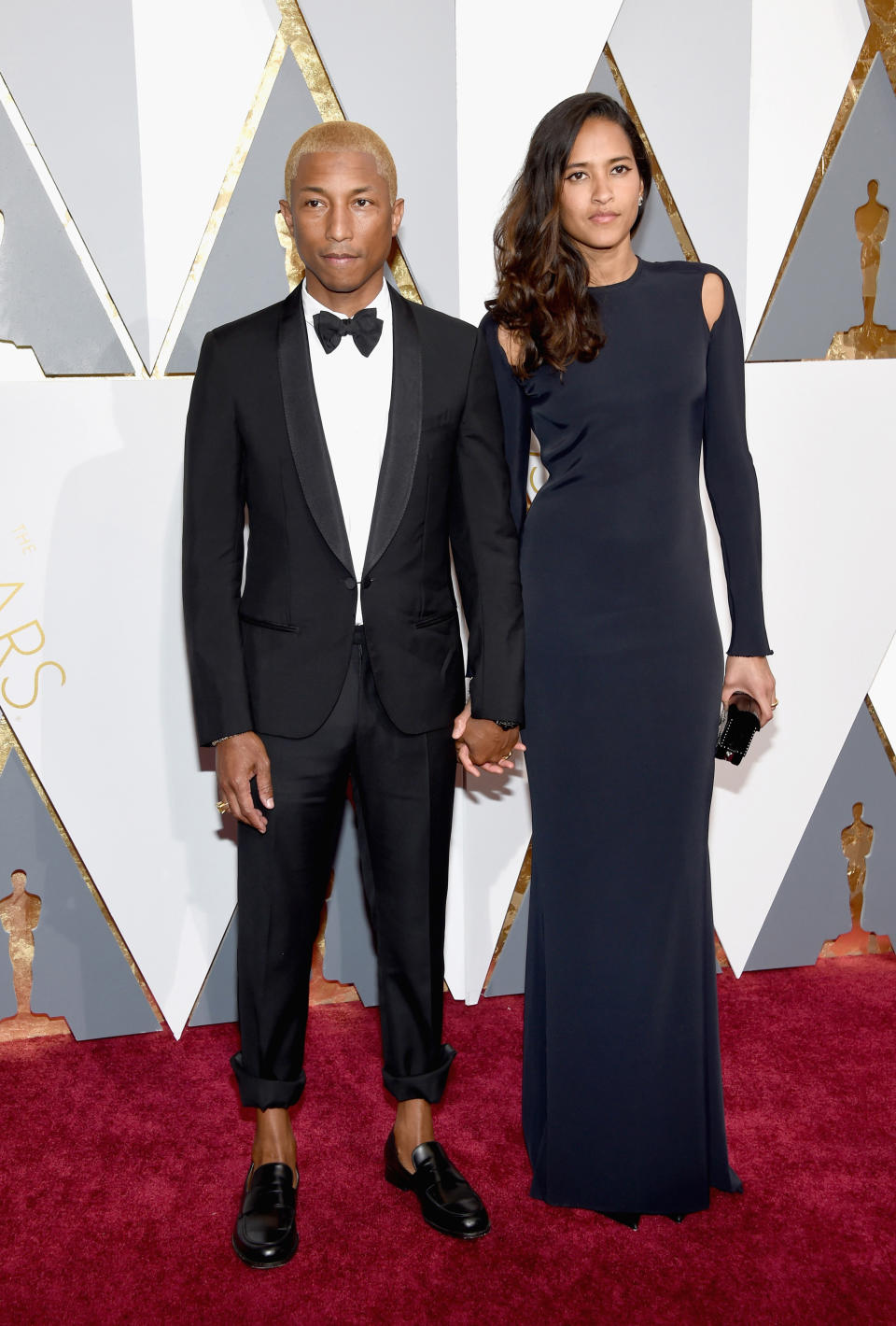 Zeigte sich bei den Oscars 2016 mit blond gefärbtem Haar, hochgekrempelter Hose und mit seiner Frau Helen Lasichanh an der Seite: der Musiker Pharrell Williams. (Bild-Copyright: Getty Images/Ethan Miller)