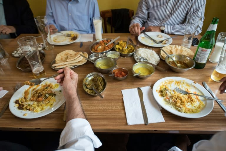 People eat lunch inside the India Club restaurant in London on October 16, 2017