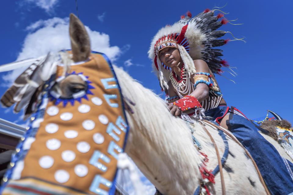 Fourteen year-old Mylan Archuleta of Ohkay Owingeh village in northern New Mexico prepares to ride his horse in the horse parade at the 40th anniversary of the Gathering of Nations Pow Wow in Albuquerque, N.M., Friday, April 28, 2023. Tens of thousands of people gathered in New Mexico on Friday for what organizers bill as the largest powwow in North America. (AP Photo/Roberto E. Rosales)