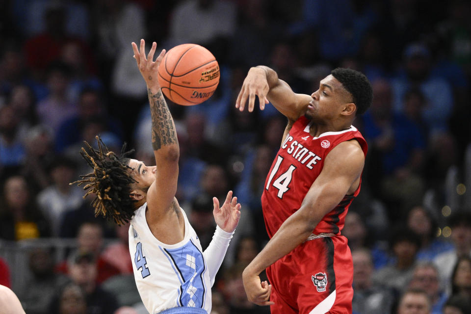North Carolina State guard Casey Morsell (14) blocks a shot by North Carolina guard RJ Davis (4) during the second half of an NCAA college basketball game in the championship of the Atlantic Coast Conference tournament, Saturday, March 16, 2024, in Washington. (AP Photo/Nick Wass)