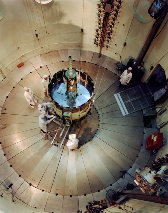 NASA's International Sun-Earth Explorer (ISEE-3) was undergoing testing and evaluation inside Goddard's dynamic test chamber when this photo was taken. Working inside a dynamic test chamber, Goddard engineers wear protective "clean room" clothi