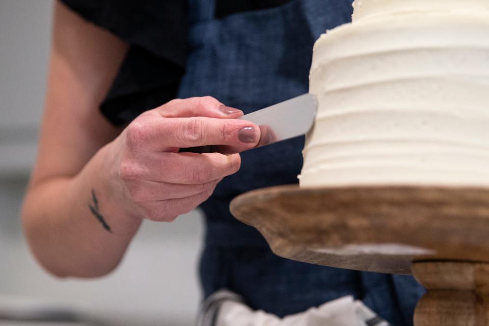 Whitney Leighton ices a cake in Boone, Iowa, in May 2022.