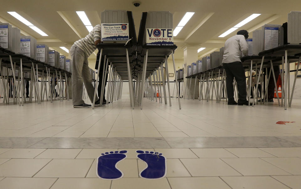 File - In this Nov. 8, 2016, file photo, voters cast ballots at City Hall in San Francisco. San Francisco will become the first city in California and one of only a handful nationwide to allow noncitizens to vote in a local election in November. They’re only allowed to vote in the school board race. (AP Photo/Jeff Chiu, File)