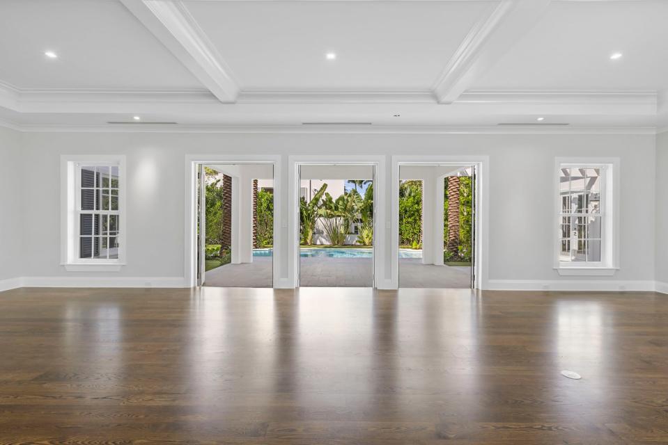 The combination living room and dining room at 130 Algoma Road in Palm Beach has French doors opening to the poolside loggia. The never-lived-in house is priced at $23 million.