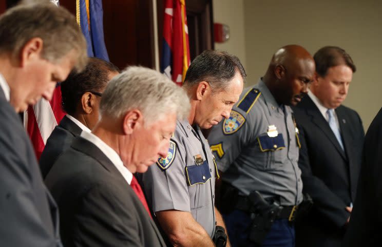 Baton Rouge police chief Carl Dabadie, Jr. center, bows his head in prayer with other officials at the start of a news conference at police headquarters in Baton Rouge, La., Wednesday, July 6, 2016. (Photo: Gerald Herbert/AP)