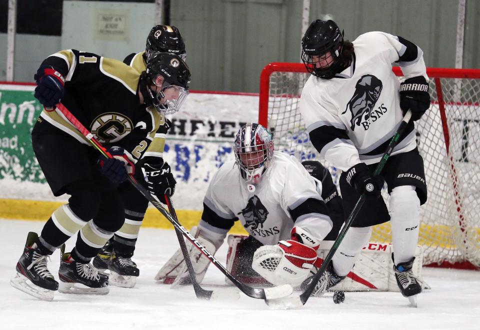 From right, BYSNS's Hart Nullet (63) clears the puck away from Clarkstown's Nick Romeo (21) in front of the BYSNS'  goal during hockey action at the Brewster Ice Arena Jan. 15, 2022.