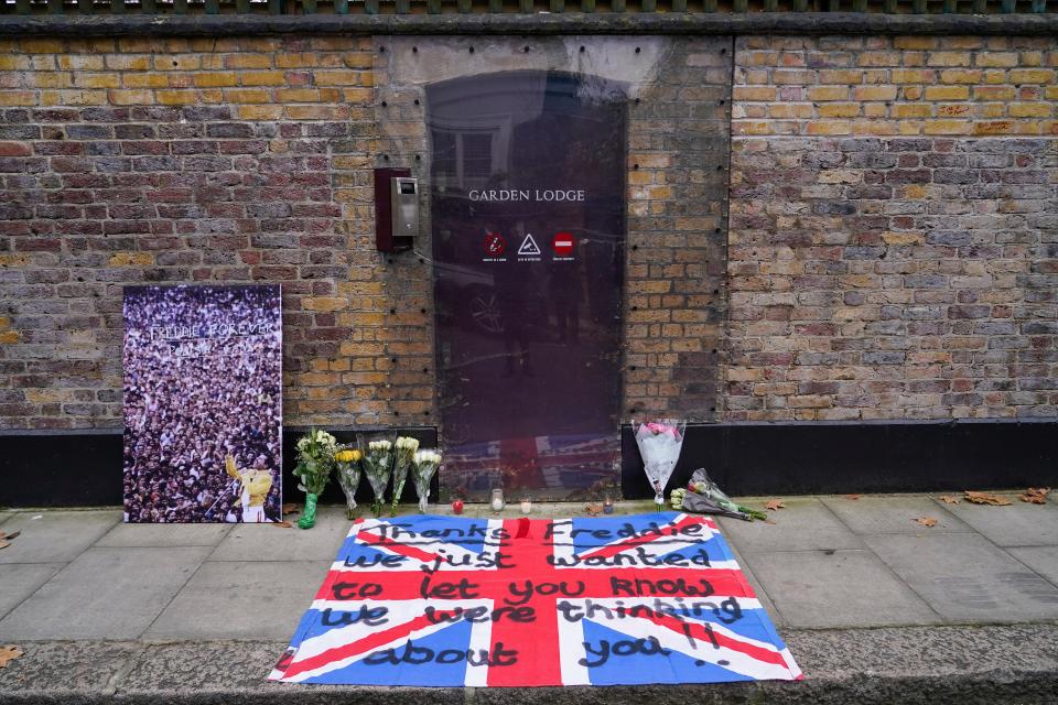 Flowers, candles, a picture and a flag with a message are left outside the late Freddie Mercury's house, on the 30th anniversary of his death, in London, Wednesday, Nov. 24, 2021.