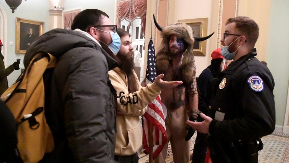 Un policía del Capitolio dialoga con simpatizantes de Trump