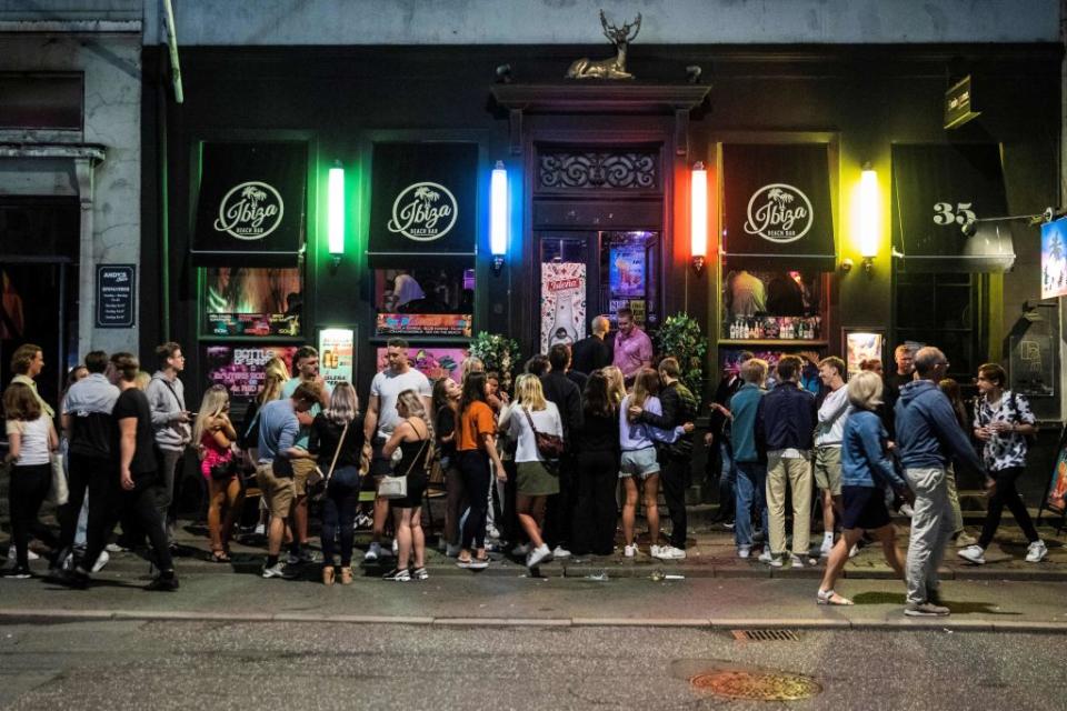 Revellers outside a bar in Copenhagen following the announcement of a curfew for social venues - getty