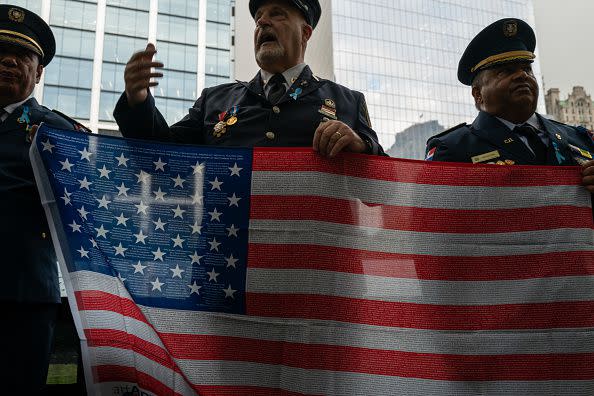 NEW YORK, NEW YORK - SEPTEMBER 11: Retired firefighter Vincent Forras holds an American Flag with the names of September 11 victims while at the 9/11 Memorial at the Ground Zero site in lower Manhattan as the nation commemorates the 22nd anniversary of the attacks on September 11, 2023 in New York City. Monday marks the 22nd anniversary of the September 11 terrorist attacks on the World Trade Center and the Pentagon, as well as the crash of United Airlines Flight 93. In total, the attacks killed nearly 3,000 people and commenced a global war on terror which included American led conflicts in both Iraq and Afghanistan.   (Photo by Spencer Platt/Getty Images)