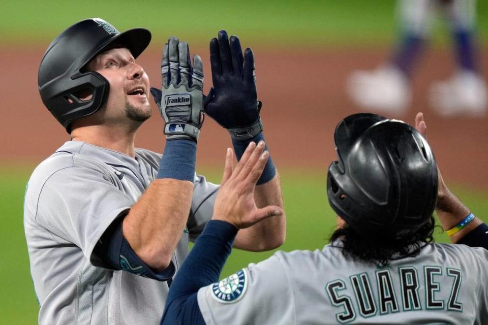 Seattle Mariners’ Cal Raleigh (29) and teammate Eugenio Suarez (28) celebrate Raleigh’s two-run home run during the first inning in Game 1 of a AL wild card baseball playoff series against the Toronto Blue Jays in Toronto on Friday, Oct. 7, 2022. (Frank Gunn/The Canadian Press via AP)
