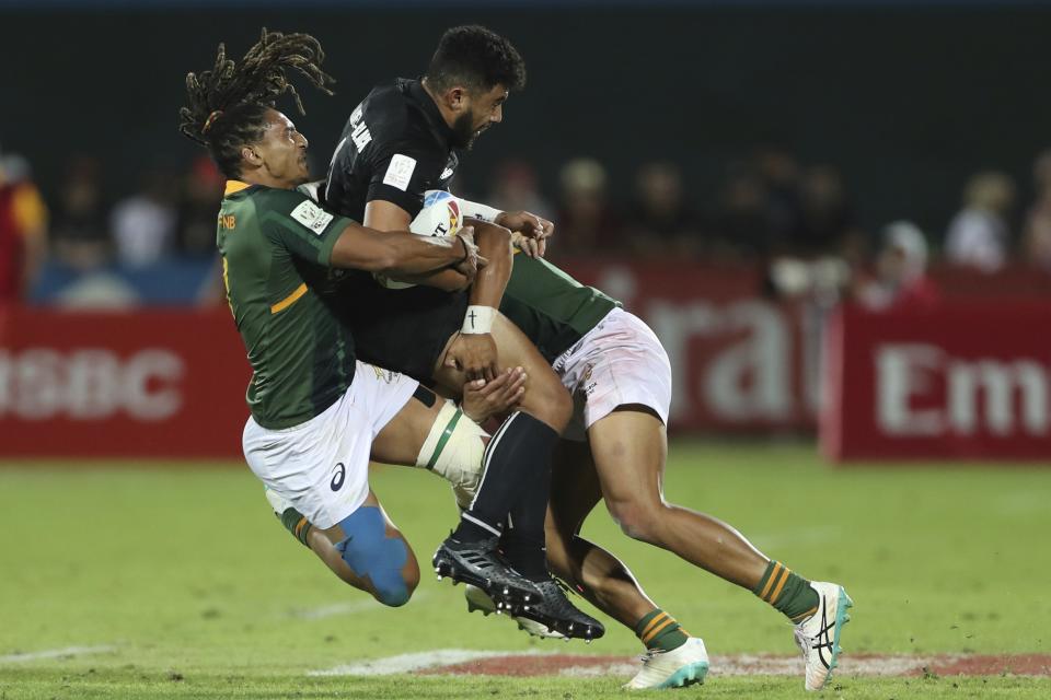 South Africa's Justin Geduld, left, tackles New Zealand's Ngarohi McGarvey-Black in the final match of the Emirates Airline Rugby Sevens in Dubai, United Arab Emirates, Saturday, Dec.7, 2019. (AP Photo/Kamran Jebreili)
