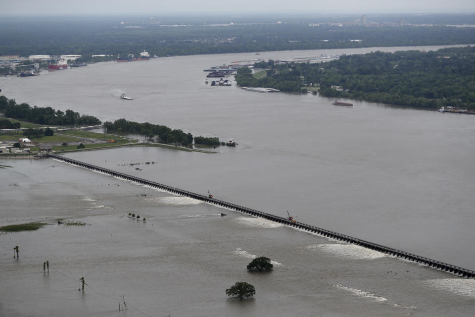 FILE - In this May 10, 2019 file photo, workers open bays of the Bonnet Carre Spillway, to divert rising water from the Mississippi River to Lake Pontchartrain, upriver from New Orleans, in Norco, La. It will be months before state officials know whether losses from floods and spillway openings qualify Louisiana as a fisheries disaster. Department of Wildlife and Fisheries officials say floods began around November 2018, and a full 12 months' data is needed to compare to averages for the previous 5 years. The governors of Louisiana, Mississippi and Alabama asked months ago for US Commerce Secretary Wilbur Ross to declare a fisheries disaster, making federal grants available to affected people. (AP Photo/Gerald Herbert, File)