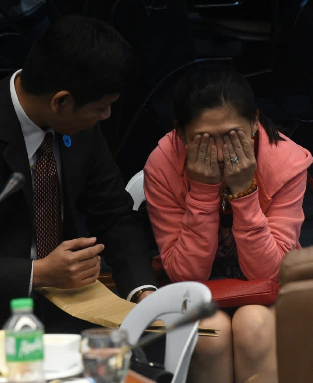 Maia Deguito, manager of the RCBC branch in Manila's financial district, confers with one of her lawyers during a senate hearing in Manila on March 17, 2016