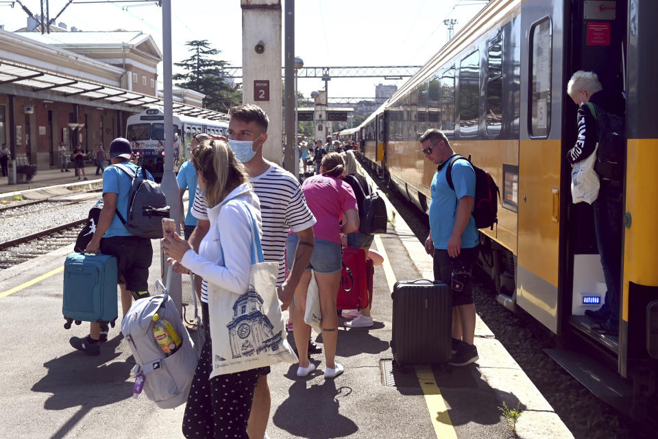 Passengers disembark from a train that arrived from the Czech Republic in Rijeka, Croatia, Wednesday, July 1, 2020. A train carrying some 500 tourists from the Czech Republic has arrived to Croatia as the country seeks to attract visitors after easing lockdown measures against the new coronavirus. (AP Photo)