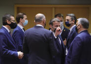 French President Emmanuel Macron, center, speaks with Hungary's Prime Minister Viktor Orban, right, during a round table meeting at an EU summit in Brussels, Thursday, Dec. 10, 2020. European Union leaders meet for a year-end summit that will address anything from climate, sanctions against Turkey to budget and virus recovery plans. Brexit will be discussed on the sidelines. (AP Photo/Olivier Matthys, Pool)