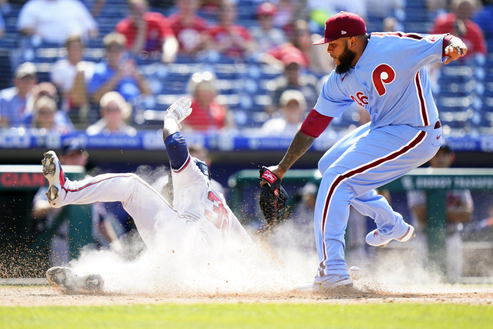 Atlanta Braves' Guillermo Heredia, left, scores past Philadelphia Phillies pitcher Jose Alvarado on a passed ball during the 10th inning of a baseball game, Thursday, June 10, 2021, in Philadelphia. (AP Photo/Matt Slocum)