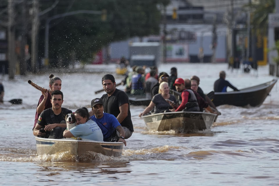 Volunteers help to evacuate residents from an area flooded by heavy rains, in Porto Alegre, Brazil, Tuesday, May 7, 2024. (AP Photo/Andre Penner)