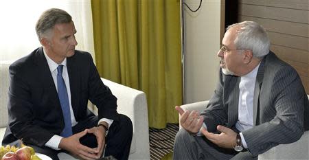 Swiss Foreign Minister Didier Burkhalter (L) talks to Iranian Foreign Minister Mohammad Javad Zarif during a private meeting before the start of the second day of closed-door nuclear talks at the United Nations offices in Geneva October 16, 2013. REUTERS/Martial Trezzini/Pool