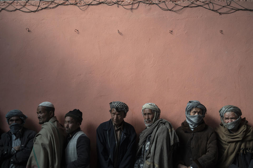 Men wait in a line to receive cash at a money distribution organized by the World Food Program (WFP) in Kabul, Afghanistan, Wednesday, Nov. 3, 2021. Since the Taliban swept into power, Afghanistan's economy has been crumbling. (AP Photo/Bram Janssen)
