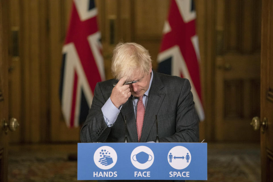 Britain's Prime Minister Boris Johnson gestures, during a coronavirus briefing in Downing Street, London, Wednesday, Sept. 30, 2020. The number of new hospitalizations for COVID-19 and virus deaths in Britain are rising again, although both remain far below their springtime peak. (Jack Hill/Pool Photo via AP)