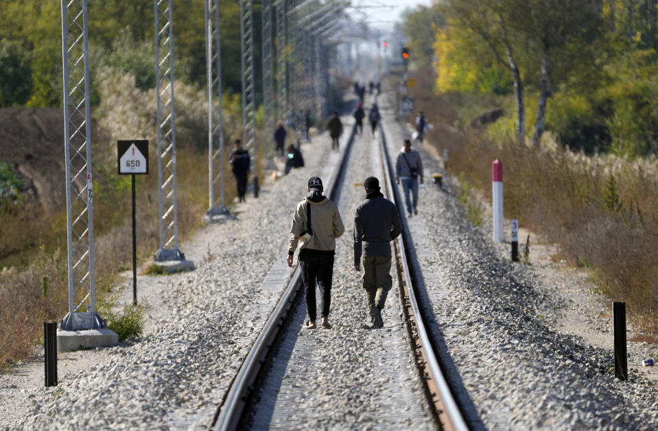 FILE - Migrants walk on the railway tracks near a border line between Serbia and Hungary, near village of Horgos, Serbia, on Oct. 20, 2022. Serbian police said Monday July 24, 2023 they have arrested two people suspected of helping smuggling Cubans toward Spain as part of an international crime group. Serbia, is at the heart of a key land route for migrants trying to reach European Union. (AP Photo/Darko Vojinovic, File)
