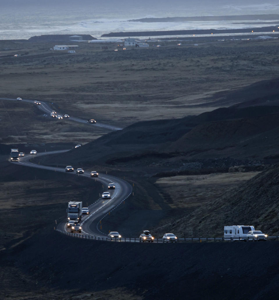 A line of cars on a road heading out of the town of Grindavik on Nov. 13, 2023. (Brynjar Gunnarsson / AP)