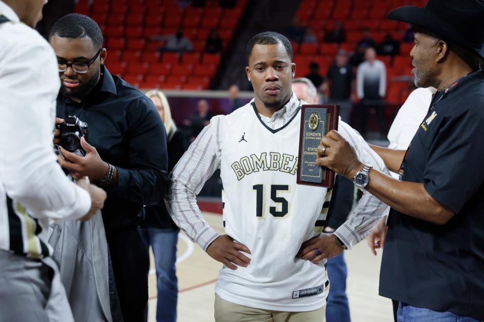 Midwest City coach Torey Noel is presented with a plaque after the Class 5A boys high school basketball state tournament championship game between Booker T Washington and Midwest City at Lloyd Noble Center in Norman, Okla., Saturday, March 9, 2024.