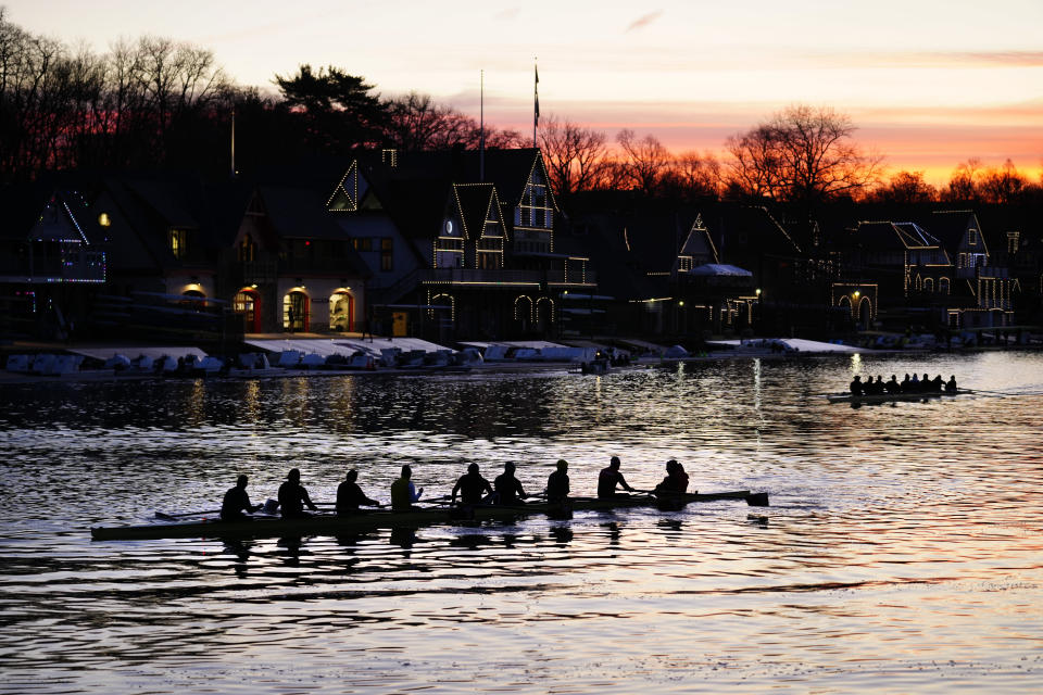 Crews set out on the Schuylkill River as lights illuminate the outline of structures on Boathouse Row in Philadelphia, Thursday, March 16, 2023. (AP Photo/Matt Rourke)