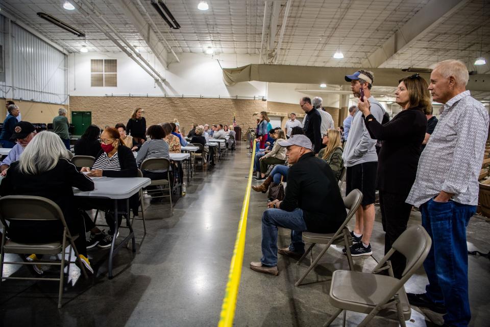 Poll watchers stand behind the yellow tape as poll officials count the ballots by hand, Wednesday, Oct. 27, 2021 at the Williamson County AG Expo Park  in Franklin, due to software issues with the voting machine tabulators. 