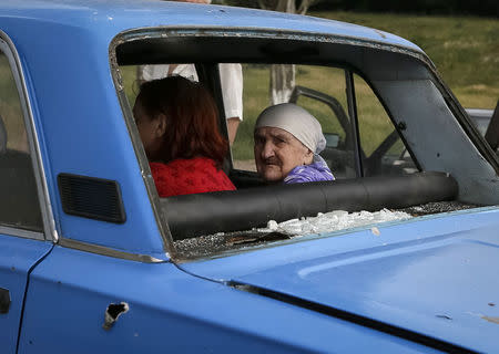 An old woman looks from inside a car with bullet holes and shattered windows as she flees fighting in the eastern Ukrainian town of Slaviansk June 9, 2014. REUTERS/Gleb Garanich