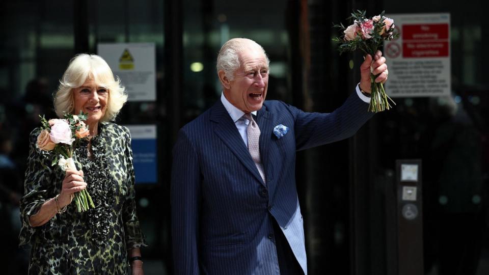 PHOTO: Britain's King Charles III and Britain's Queen Camilla, holding bunches of flowers, wave to crowds after to visit to the University College Hospital Macmillan Cancer Centre in London on April 30, 2024. (Henry Nicholls/AFP via Getty Images)