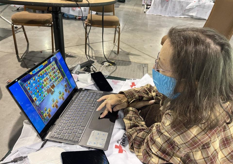 Sheryl Kirkbride plays a game of Fishdom on her laptop as she takes refuge at the American Red Cross shelter at the Ocean Center in Daytona Beach. Sheryl Kirkbride, her husband and two cats fled from their South Daytona home after rains from Tropical Storm Ian sent water gushing into their house.